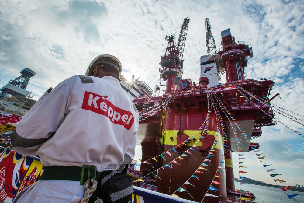 A worker stands in front of the Floatel Triumph, a semi-submersible accommodation rig operated by Floatel International Ltd. and developed by Keppel Offshore & Marine Ltd.'s deep water technology group, during a media tour in Singapore, on Friday, March 11, 2016. Keppel Corp., parent company of Keppel Offshore & Marine, is the world's biggest builder of oil rigs. Photographer: Nicky Loh