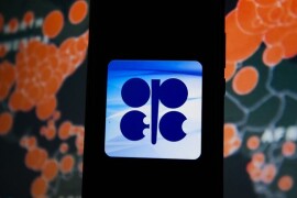 POLAND - 2020/03/19: In this photo illustration an OPEC logo seen displayed on a smartphone with a World map of COVID 19 epidemic on the background. (Photo Illustration by Omar Marques/SOPA Images/LightRocket via Getty Images)